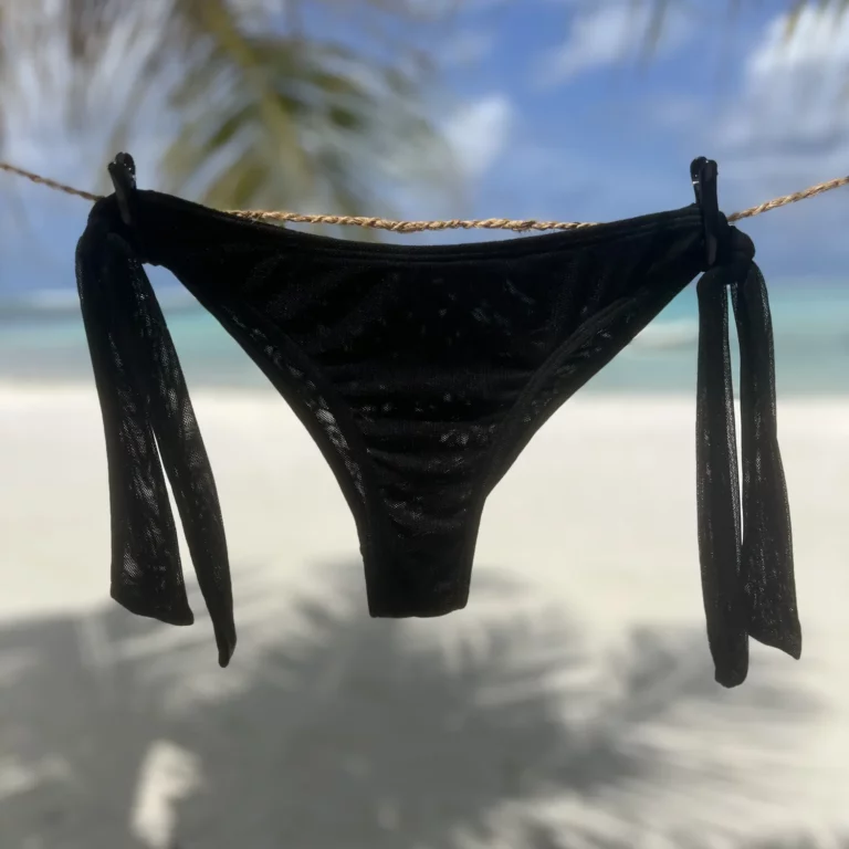 Black Ava bikini bottom with adjustable ties for comfortable, chic tanning.