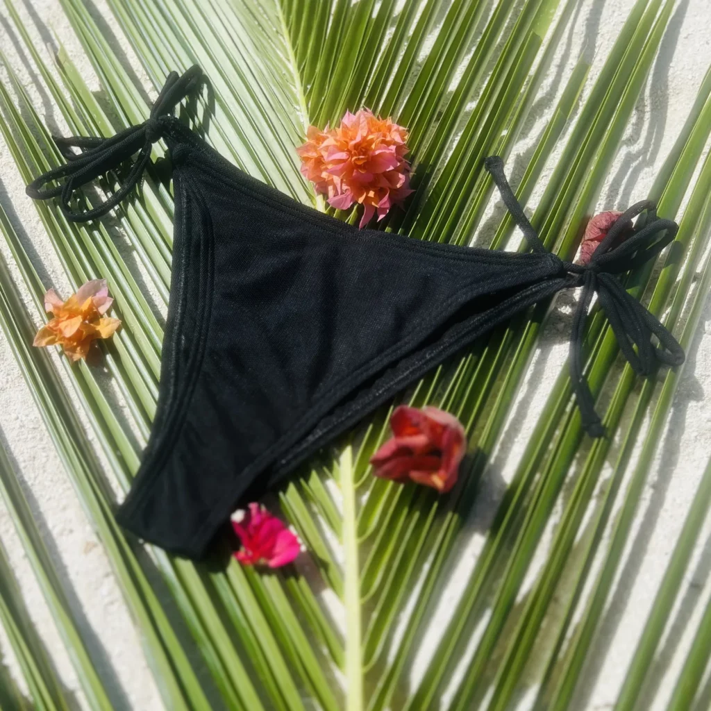 Black mid-rise Chloe Bikini Bottom with adjustable tie sides for a flawless fit.