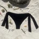 Chic black Ava bikini bottom with adjustable ties for comfort and optimal tanning.