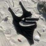 Sienna One Piece, a black tan-through high-waisted swimsuit with adjustable back ties.
