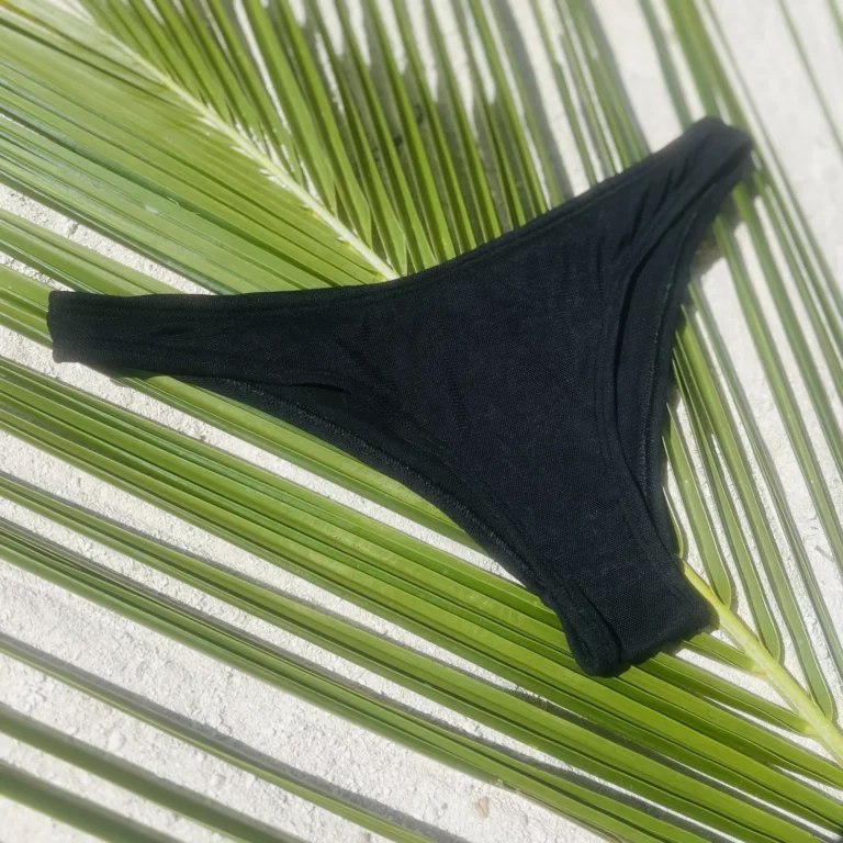 Mid-rise Zara Bikini Bottom in black tan-through fabric, ideal for sunbathing.